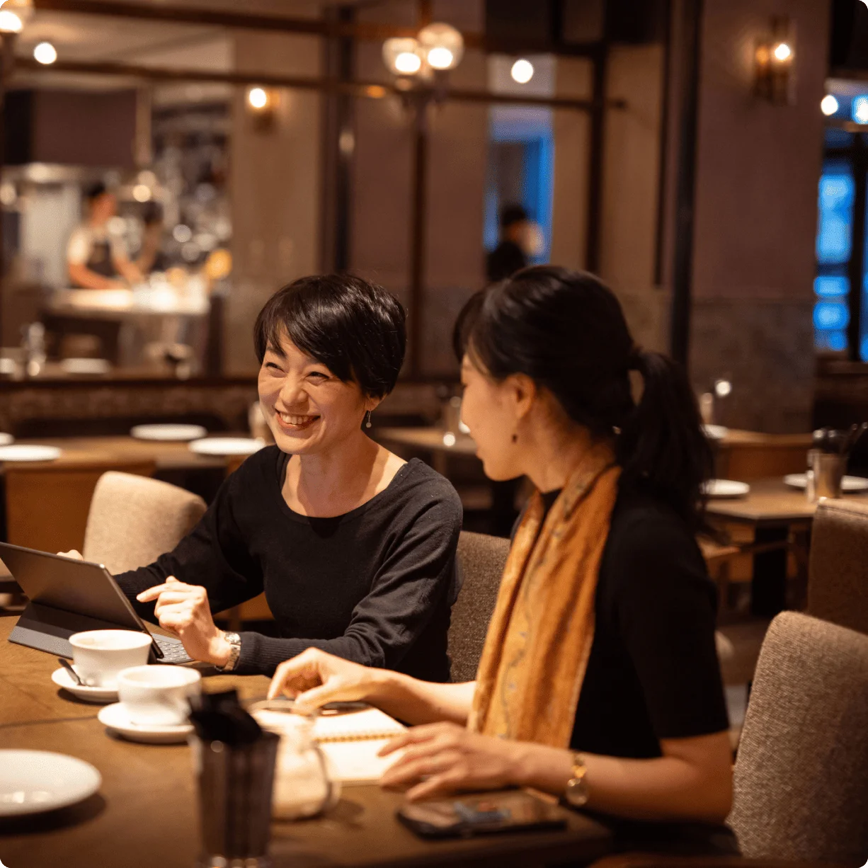 レストランでタブレットを見ながら話す女性スタッフ